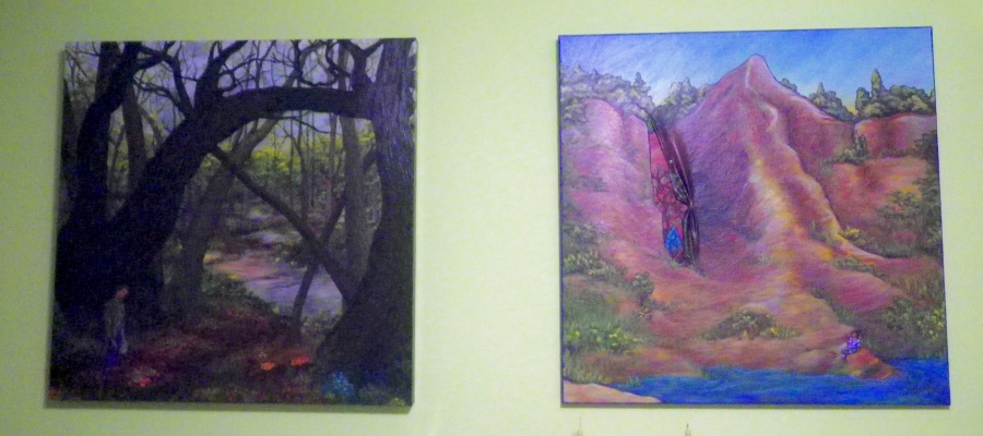 Two paintings on a green wall. One shows a person standing in a glade of large trees. Pools of water reflect sunlight in the forest behind them. The second shows a person sitting below a cliff at a lakeside. The canvas has been cut and pulled back at one point and shows a painting of the cliff and tress in a different style. 